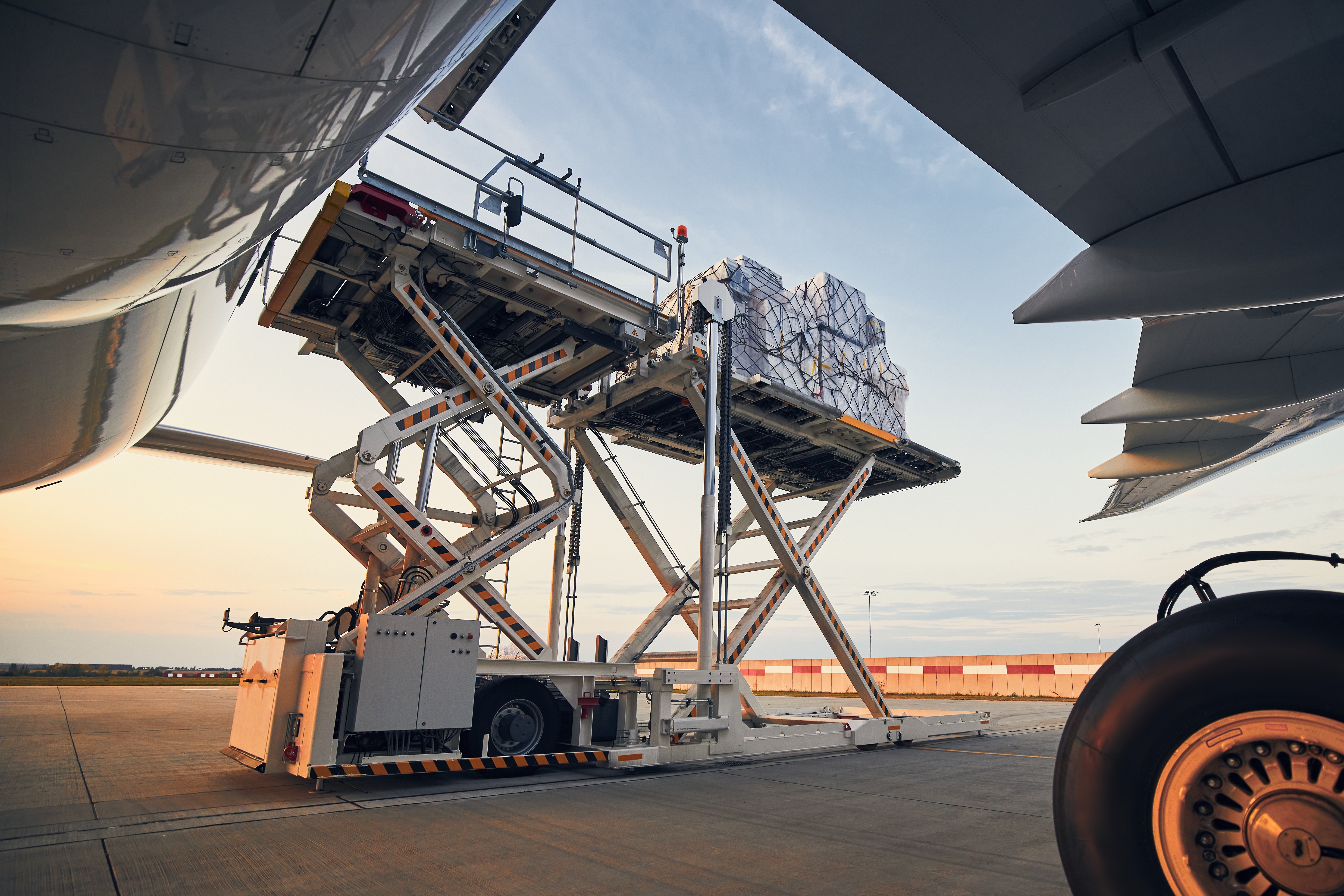 loading-of-cargo-containers-to-airplane-at-sunset-2023-11-27-05-27-27-utc